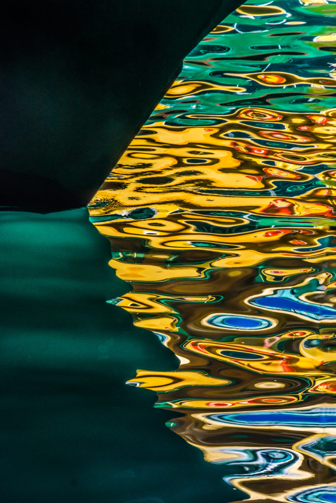 Colour photograph of rippling abstract pattern water reflection coming from Sydney Harbour ferries, Circular Quay, Australia